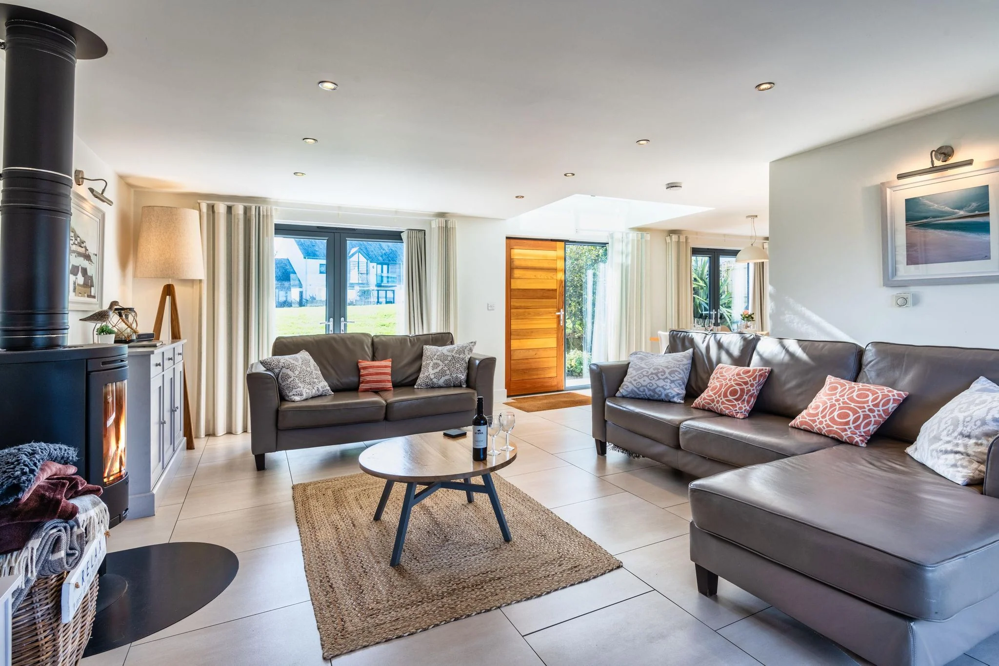 Arundell lounge with comfortable sofas and a contemporary wood-burning stove