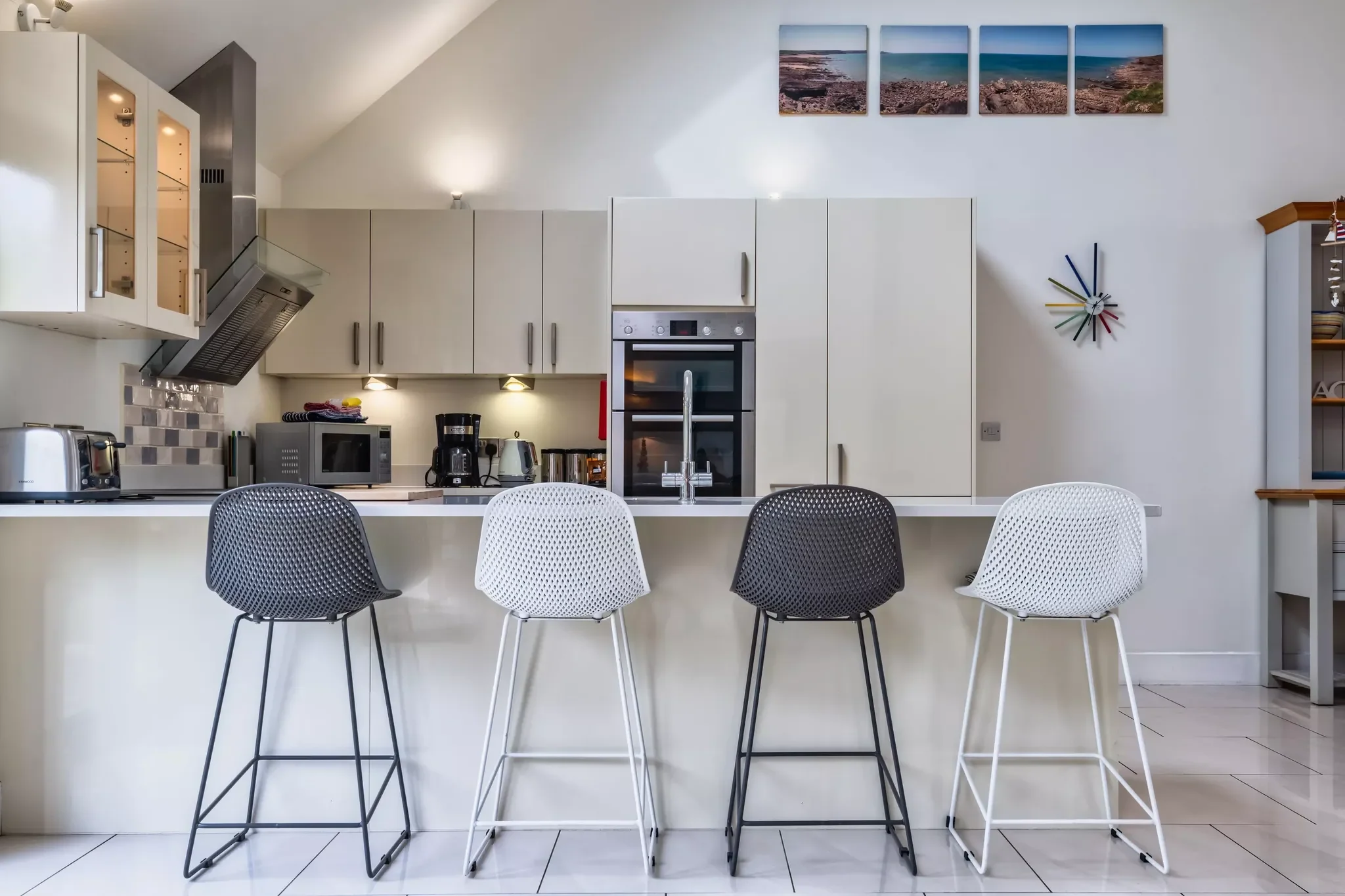 Beachcombers kitchen with a breakfast bar, integrated ovens and coastal artwork