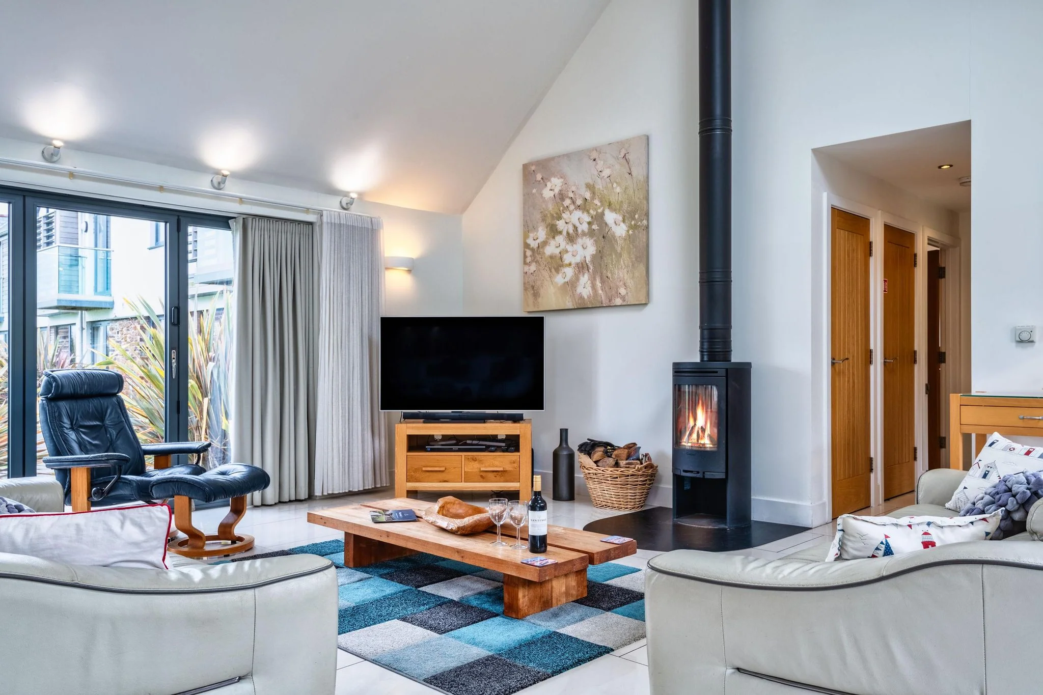 Beachcombers lounge with a wood-burning stove, armchair and doors to the garden