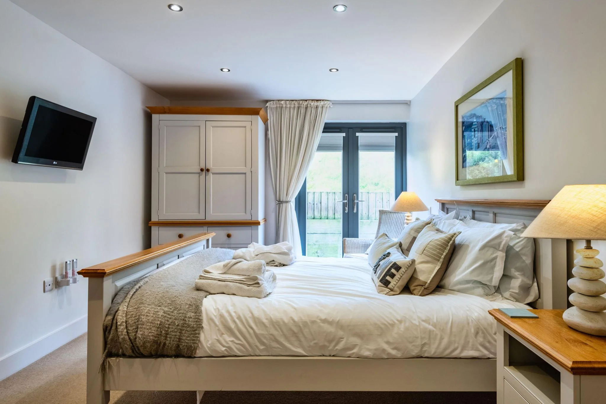 Beachcombers master bedroom with a double bed, wardrobe and doors to the garden