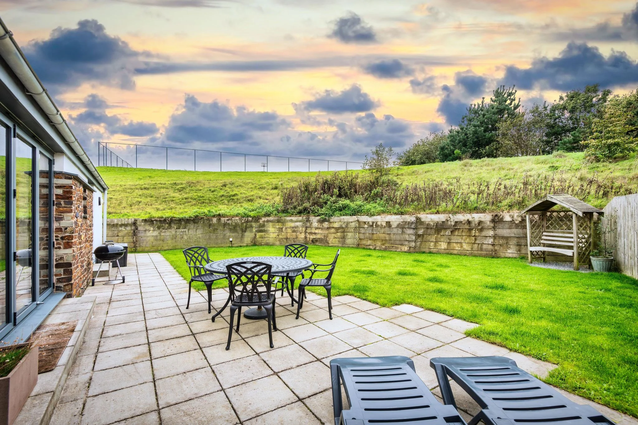 The terrace and lawned garden at Beachcombers, with outdoor dining and sun loungers