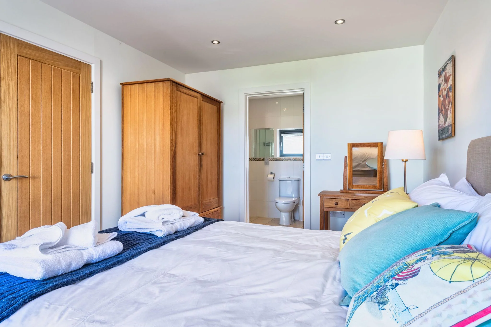 Chapel Park double bedroom showing the oak wardrobe, dressing table, and open doorway into the private en-suite shower room.