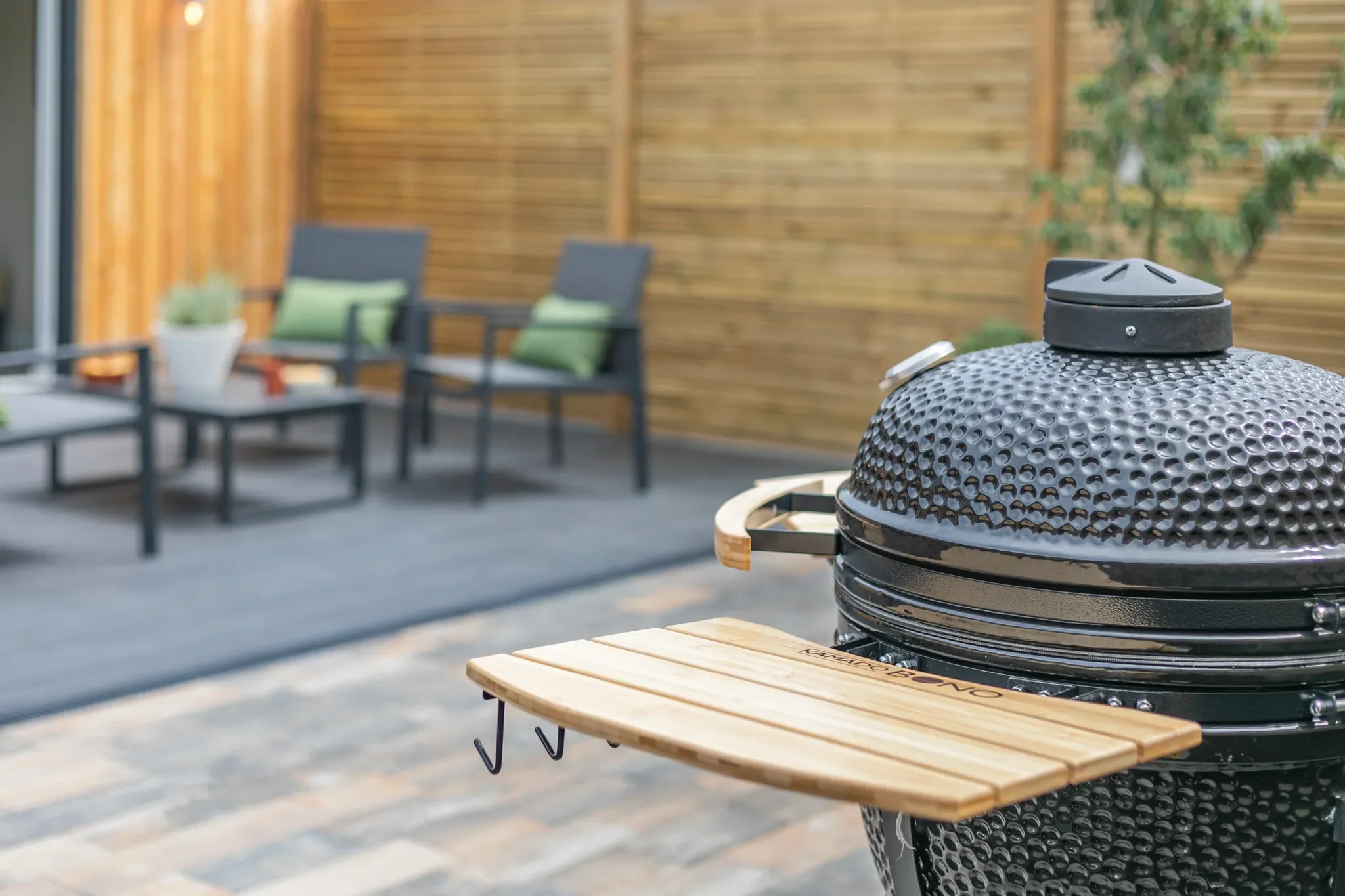 Gwari Spa Barn kamado grill on the courtyard patio with outdoor seating and slatted timber privacy fencing.