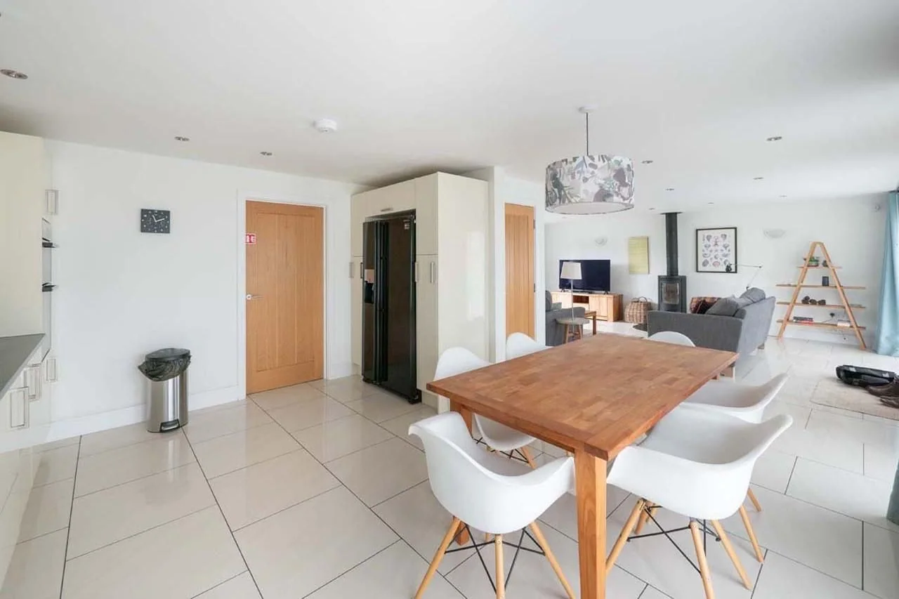 Medlands kitchen and dining space from the kitchen end, showing the American-style fridge-freezer and open-plan flow into the living area.