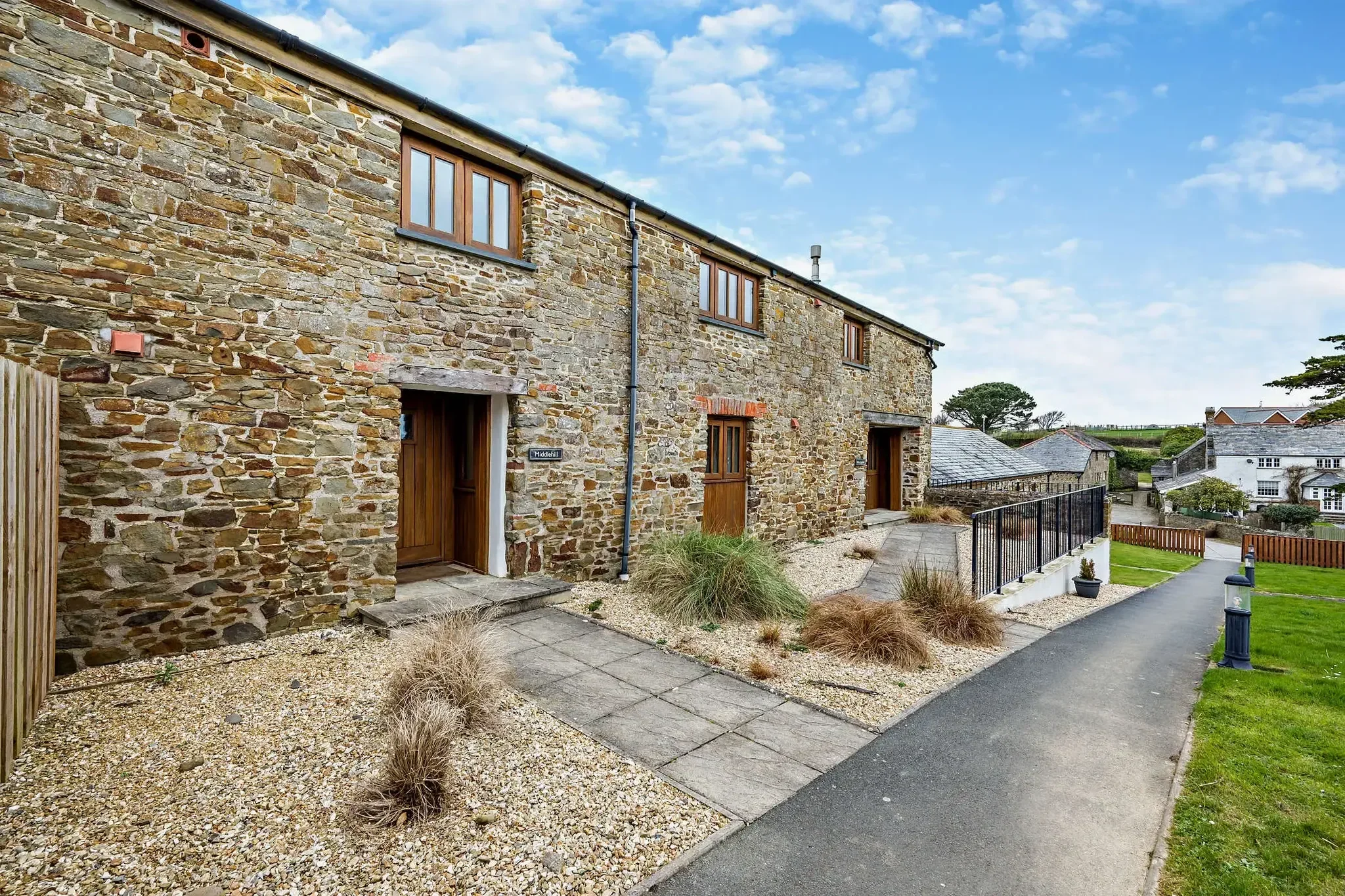 Middle Hill cottage seen from the rear, showing the stone-built back elevation, shared driveway, and surrounding grounds.