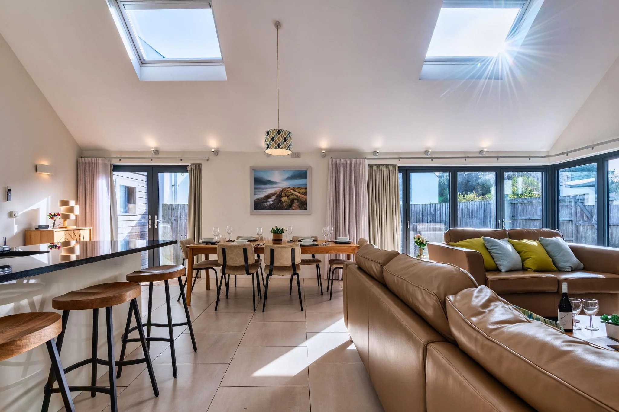 Nettlecoombe dining area with a long table for eight, bar stools at the island and twin skylights flooding the room with light.