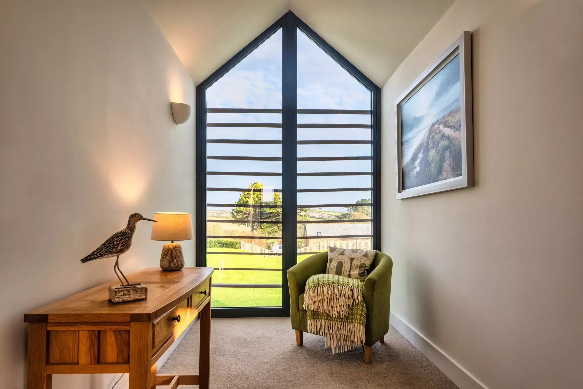Trevelyan master bedroom's vaulted reading nook with floor-to-ceiling gabled window overlooking open countryside.