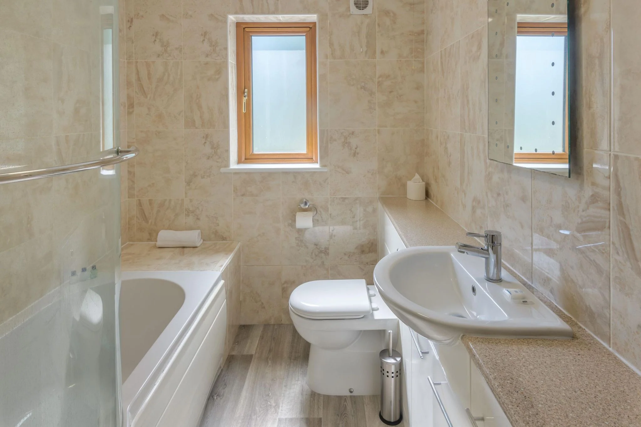 Windy Hills family bathroom with travertine-effect tiling, full-size bath, WC, and pedestal basin.