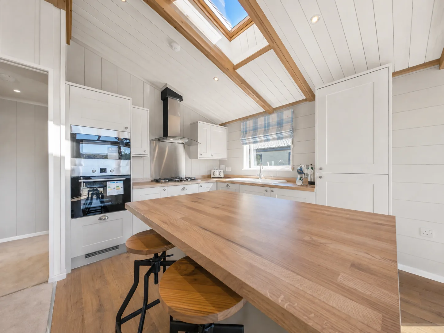 Kitchen of the two-bedroom Gwithva lodge, with shaker units, oak worktops and a roof light