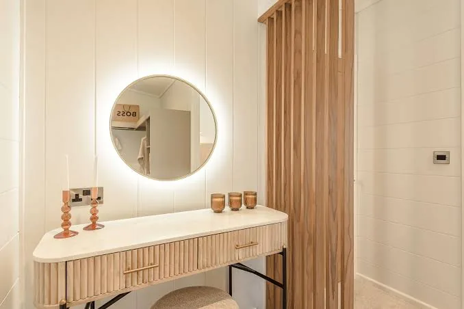 Dressing area of the three-bedroom Gwithva Prestige Skylark, with a fluted vanity and backlit mirror