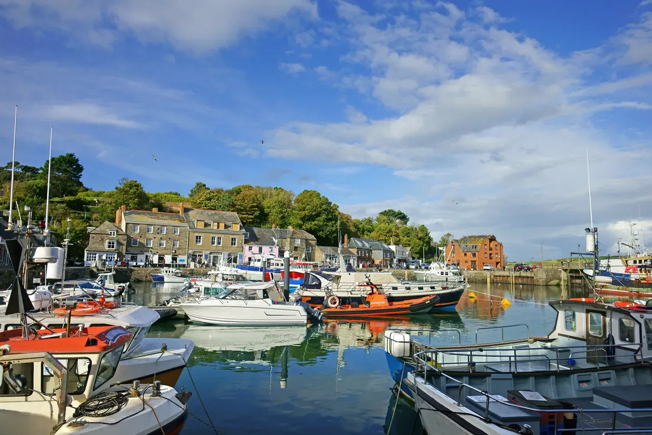 Fishing boats moored in Padstow harbour beneath blue skies, North Cornwall