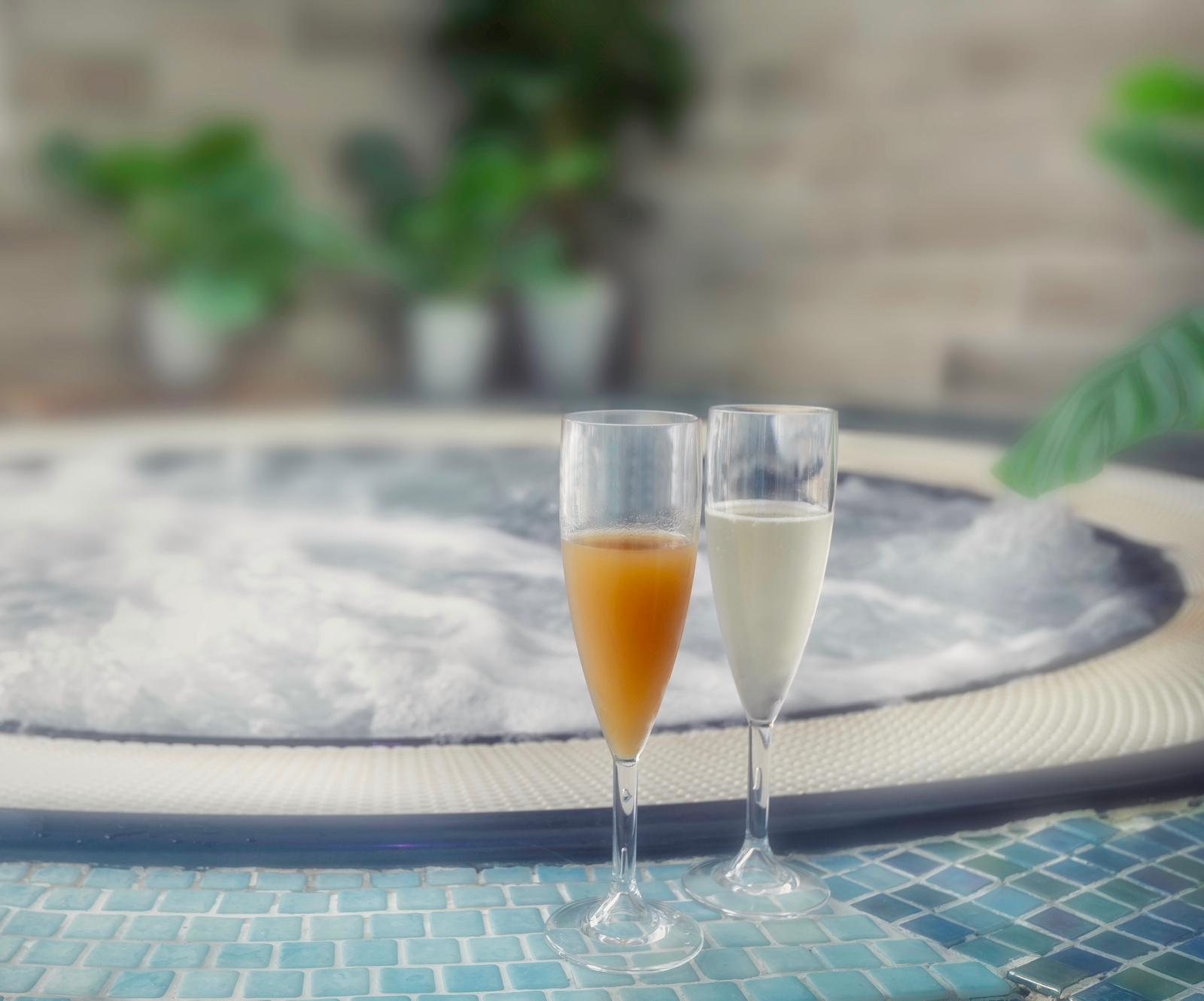 Bubbling hydrotherapy jacuzzi with two glasses of fizz at the edge at The W Club, Whalesborough, Bude, Cornwall